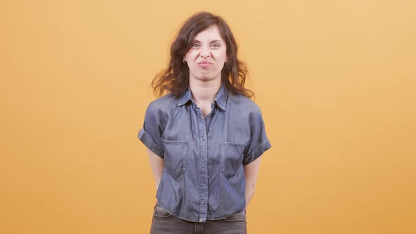 Pretty Woman Over Yellow Background Showing Funny Faces To the Camera
