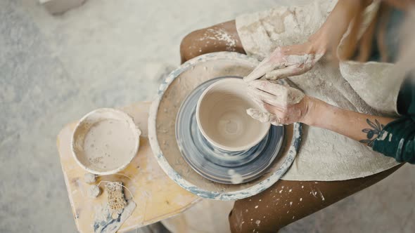 Top View on Pottery Wheel and Artist Hands Creating Ceramic Bowl Tracking Shot Slow Motion