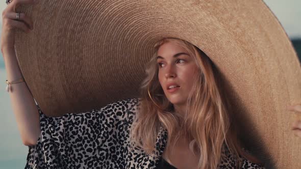 Beautiful Girl Wearing Big Straw Summer Hat on the Beach