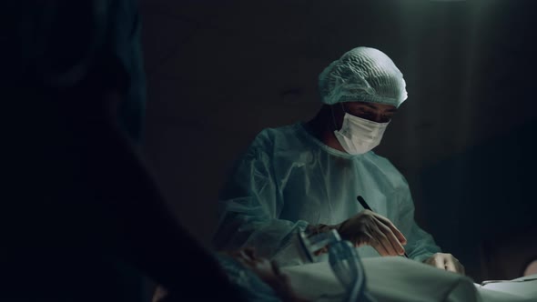 Surgeon Operating in Dark Emergency Ward