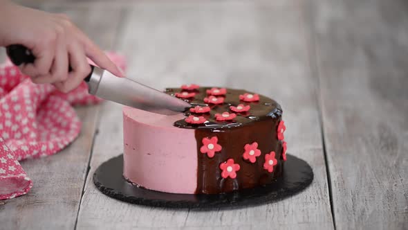 wCutting a Strawberry Mousse Cake with Mirror Glaze