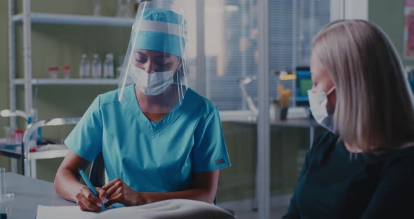 Black Doctor Speaking with Female Patient