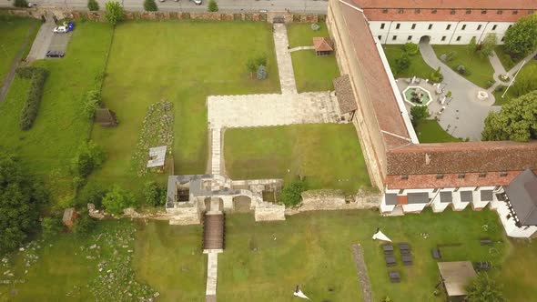 Aerial Top down Shot with Pan of Citadel Walls/ruins with Orthodox Roofs and Trees visible in Alba-C