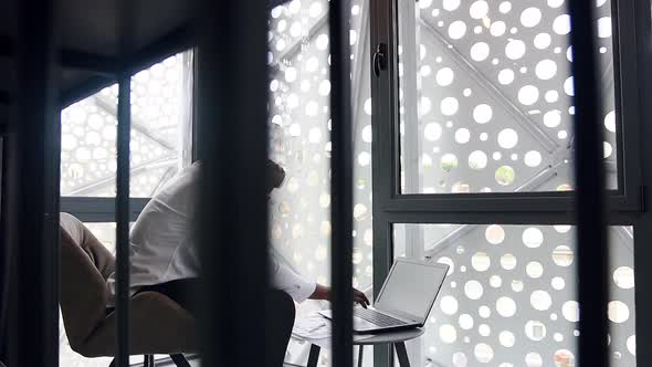 African American Manager Working with Computer and Drinking Coffee in Specially Designted Room