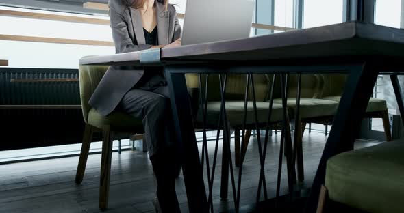 Concerned Woman Working on Laptop Computer and Looking Away Thinking Solving Problem at Office