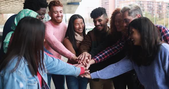 Multiracial young people stacking hands outdoor