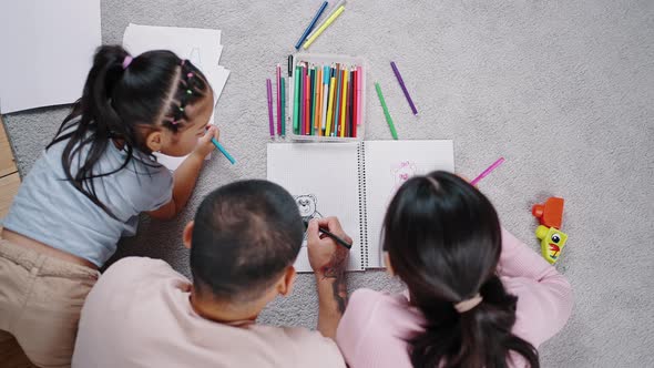 Asian Family Spends Time Together Drawing Pictures on Paper