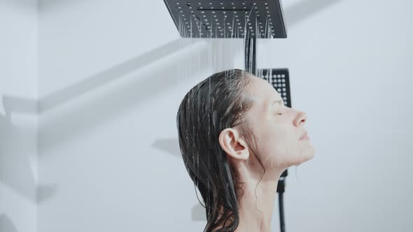 Female Puts His Face Under the Drops of Water