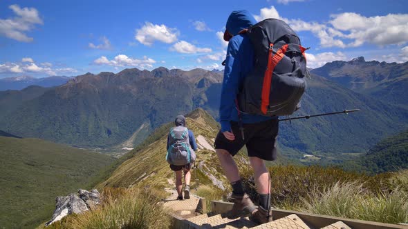 Static, hikers descend exposed alpine ridge, vast Fiordland landscape, Kepler Track New Zealand