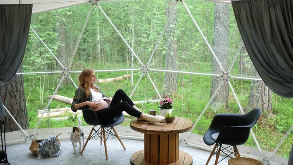 pregnant with headphones on her stomach with music therapy in a tent the forest