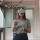 Young woman looking around in virtual reality goggles experiencing the metaverse - VideoHive Item for Sale