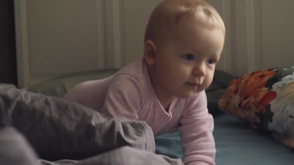 Active Smiling Baby Girl on the Bed at Home