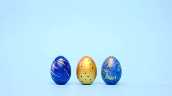 Easter Eggs are Rolling Knocking Each Other on Blue Table