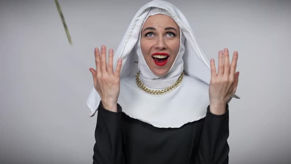 Portrait of Praying Woman in Nun Costume Posing with Excited Facial Expression As Money Falling in