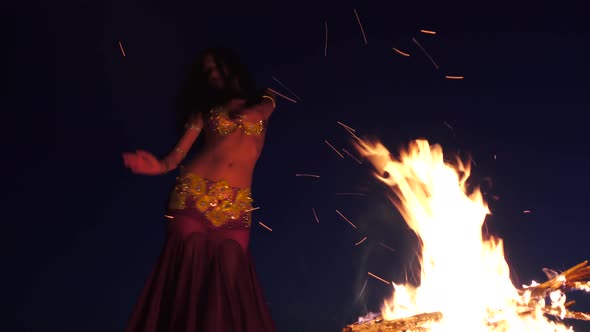 Girl in the Sand Dancing Belly Dancing Near a Bright Campfire