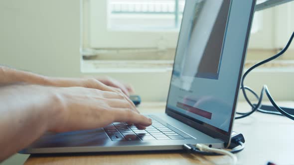 Man hands typing on a laptop computer keyboard