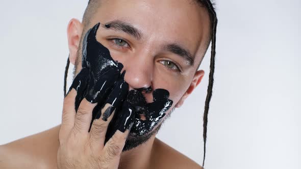 Handsome Person Stylish Applying Mask Mud Face Close Up on White Background .