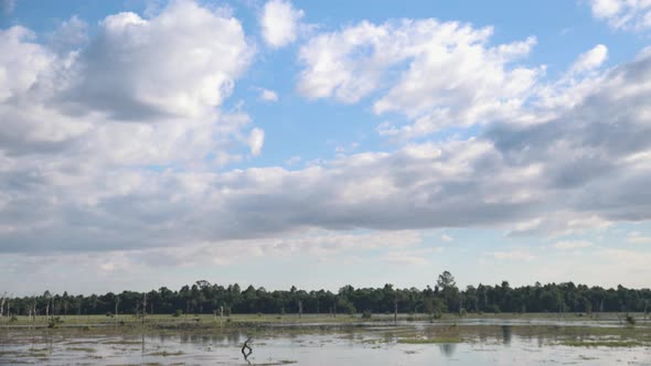 Wide, exterior, Time lapse Shot of White Clouds Drifting Above Flood Plain in Daytime