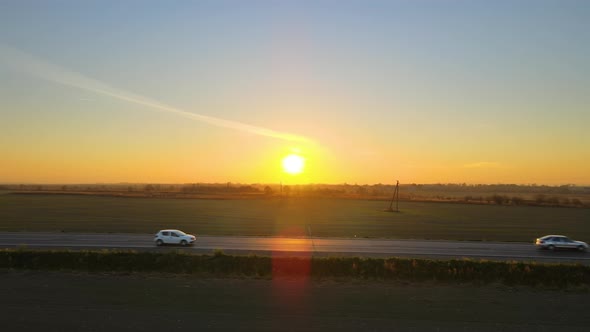 Aerial View of Intercity Road with Fast Driving Cars at Sunset