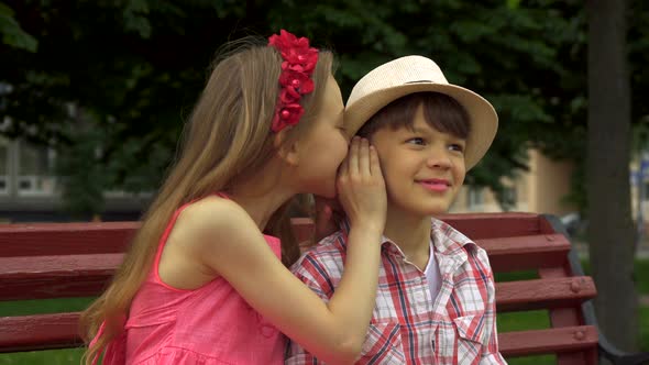 Little Girl Shares Secrets with Boy on the Bench