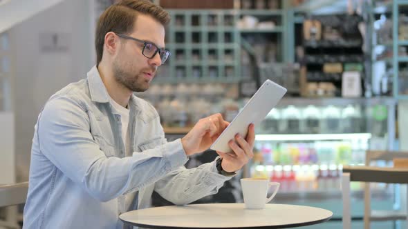 Man Using Tablet in Cafe