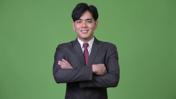 Young Handsome Asian Businessman Smiling with Arms Crossed