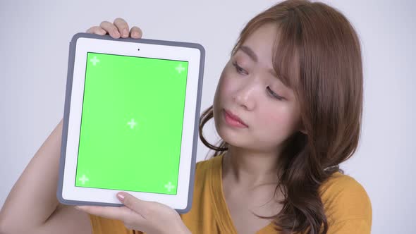 Face of Happy Young Beautiful Asian Woman Showing Digital Tablet