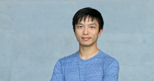 Asian young man smile to camera over grey background 