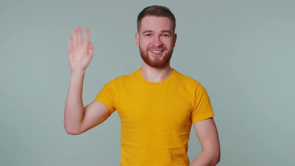 Bearded Man Smiling Friendly at Camera and Waving Hands Gesturing Hello or Goodbye Welcoming