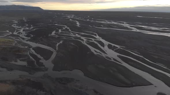 Aerial Flyover Glacial Rivers with a Low Summer Sun.