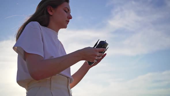 A Beautiful Girl Folds a Drone and Puts It on Her Hand. Technological Gadget in Women's Hands at