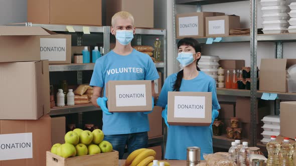 Team of Volunteers in Face Masks Holding Donation Boxes