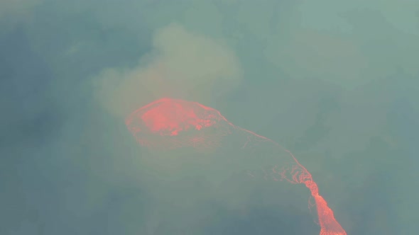 Aerial view around a volcano crater, in middle of thick sulfur smoke - orbit, drone shot