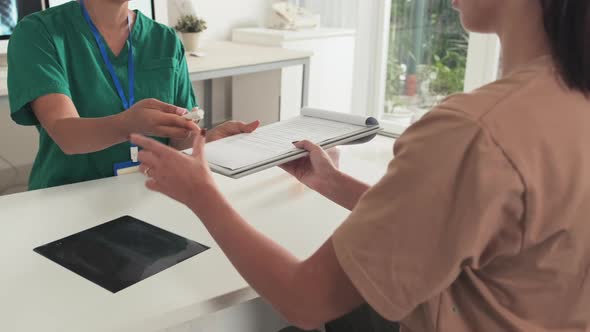 Doctor and Patient Signing Medical Agreement in Clinic