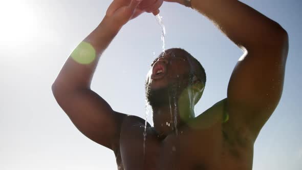 Man pouring water on his head at beach 