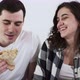 A Happy Couple Man and Woman are Eating Pizza in a Bed at Home - VideoHive Item for Sale