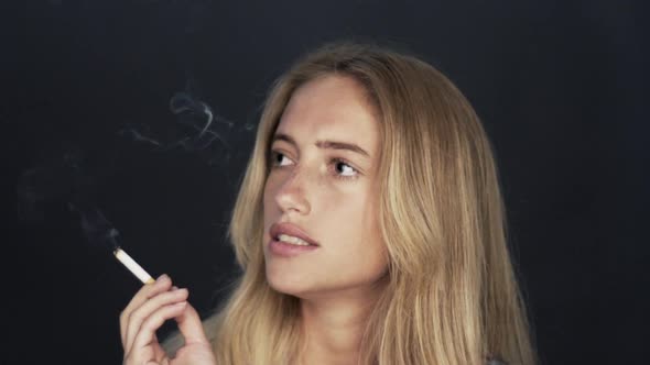 Slow motion shot of young woman smoking