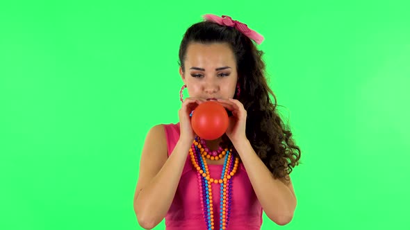 Curly Girl Inflates a Bright Red Ball Then Rejoicing