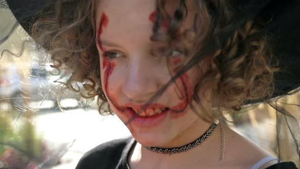 Portrait of a Teenage Girl Dressed As a Witch with Scary Makeup on Her Face