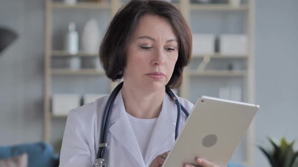 Old Senior Doctor Using Tablet for Browsing Internet