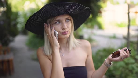 Young Stylish Beautiful Woman in Hat Using a Smart Phone