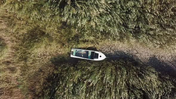 Top View of Boat at Shore of Dried Up Sea Global Warming and Drought Concept