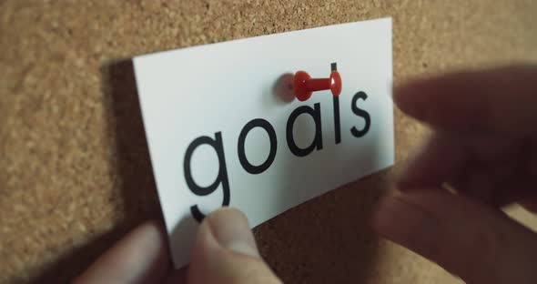 Sticky note: GOALS - Pinned to cork wall