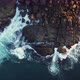 Aerial drone view of ocean blue waves break on high cliff of a rocky mountain at sunrise - VideoHive Item for Sale
