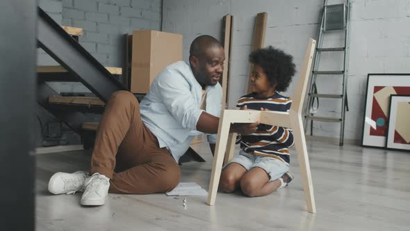 Happy Father and Son Assembling Chair