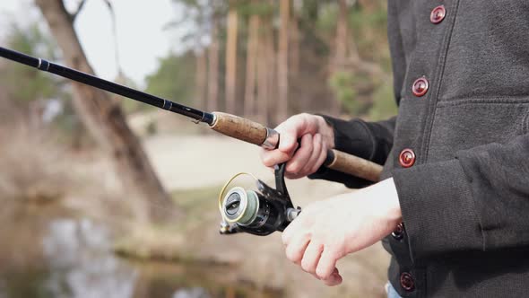 The guy in his free time catches a predatory fish on spinning from the shore. Fishing as a hobby.