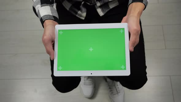 Man Sitting on Chair Looking at Digital Tablet with Green Screen Chroma Key