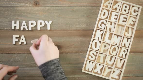 Unfinished wood letters sign Happy Father's Day on a painted wood background