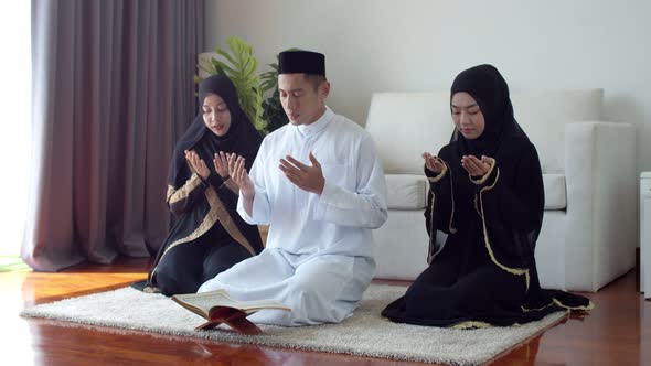 Young Islamic people praying with reading the Quran