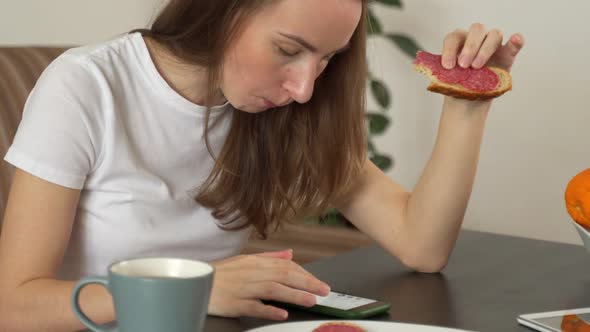 Woman Using a Smartphone at Home in a Modern Kitchen